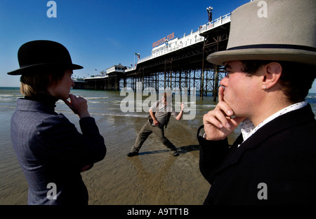 L'écrémage de pierre la concurrence sur la plage de Brighton. Candidat à l'un des lobs une pierre, assisté par deux juges, l'une dans un bowler, l'un dans un top hat Banque D'Images