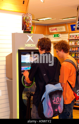 Les mâles adolescents jouer à des jeux d'arcade sur une X-box système. Banque D'Images