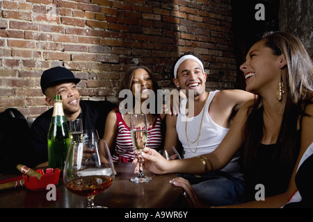Les jeunes hommes et femmes dans la mode hip-hop à faire la fête dans un bar Banque D'Images
