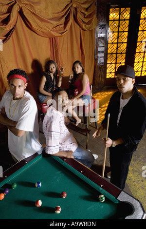 Portrait de jeunes hommes dans la mode hip-hop appuyé contre une table de billard Banque D'Images