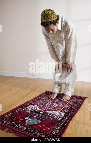 Un musulman de prier sur un tapis de prière Banque D'Images