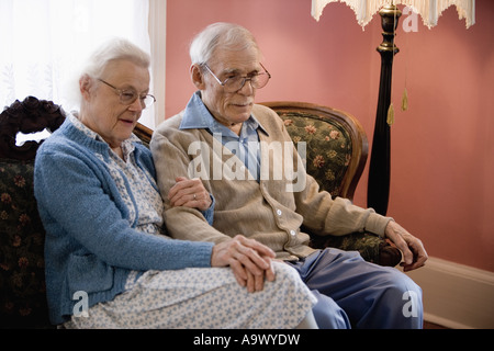 Pensive senior couple sitting on sofa Banque D'Images