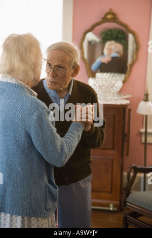 Senior couple dancing in living room Banque D'Images