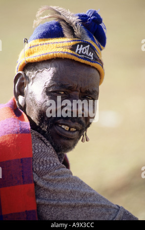 Lolgorian, au Kenya. Manyatta Masaï Siria ; ancien portant un bonnet de laine bleu et jaune avec 'Holy' d'un insigne, barbe. Banque D'Images