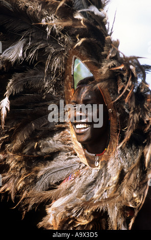 Lolgorian, au Kenya. Manyatta Masaï Siria ; 'tête de lion' moran avec coiffe de plumes symbolique avec des perles et des cauris. Banque D'Images