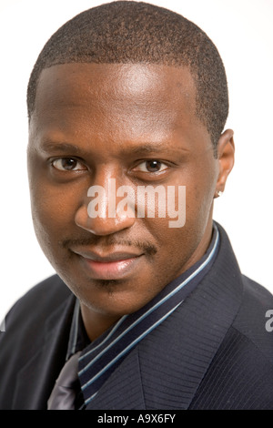 Jeune homme noir en costume et cravate portant une boucle d'oreille et smiling at the camera Banque D'Images