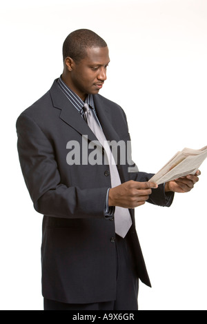 Jeune black business homme portant un costume et une cravate et lire un journal Banque D'Images