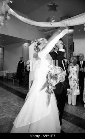 Pologne, Lodz, Bride and Groom dancing au mariage, vue latérale (B&W) Banque D'Images