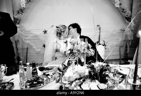 Pologne, Lodz, Bride and Groom kissing at wedding party (B&W) Banque D'Images