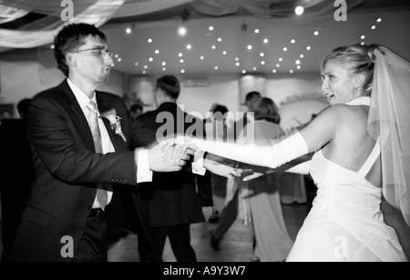 Pologne, Lodz, Bride and Groom dancing au mariage, vue latérale (B&W) Banque D'Images