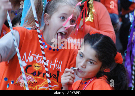 Deux jeunes filles en orange avec Notting Hill Carnival t shirts à la grande aspiration carnival procession london uk Banque D'Images