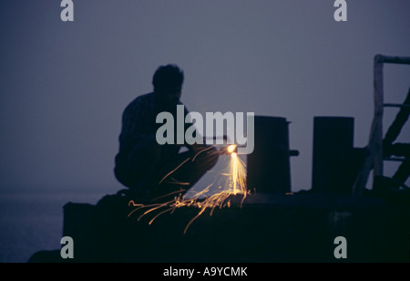 Un travailleur de souder sur le chantier de ferraille Sewri, Mumbai. Banque D'Images