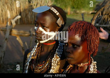 Les jeunes femmes de l'Hamar personnes transportant de nombreux colliers une plaque de métal cap et de parures Turmi Ethiopie Banque D'Images
