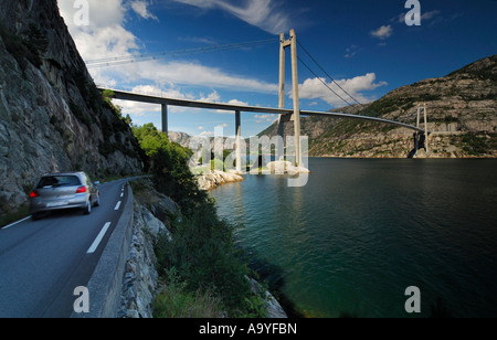 Conduite de voiture sur une rue longeant le Lysefjord avec pont suspendu, Dale i Sunnfjord, Rogaland, Banque D'Images