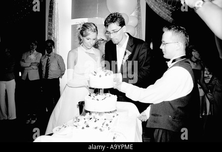 Pologne, Lodz, mariée et le marié le tranchage cake en mariage (B&W) Banque D'Images