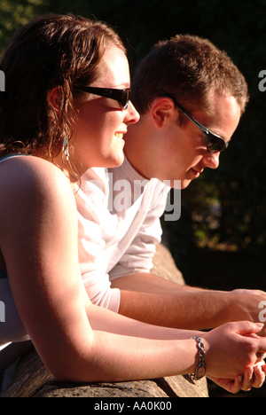 Close up of young couple looking over wall profitant de chaque compagnie d'autres personnes Banque D'Images