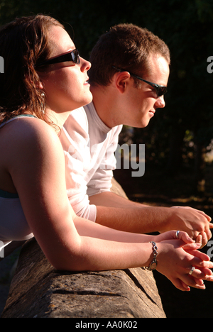 Close up of young couple looking over wall profitant de chaque compagnie d'autres personnes Banque D'Images