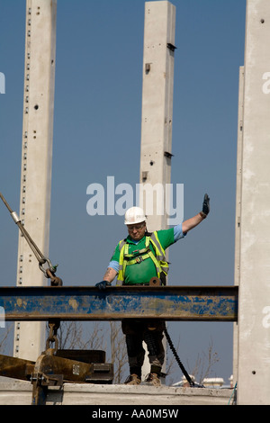 Construction Worker wearing hard hat harnais de sécurité haute visibilité casque gants et donnant des directives sur le haut du site Banque D'Images