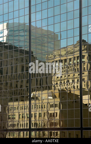 Les bâtiments traditionnels reflète dans la paroi en verre d'un gratte-ciel dans le centre-ville de Montréal Québec Canada Banque D'Images