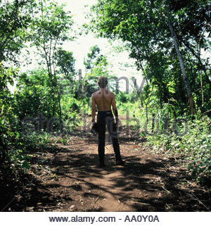 Pavuru, village indien au Brésil. Sting dans la forêt tenant une borduna Indian club ; zone indigène du Xingu, Nov 1990. Banque D'Images