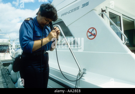 Un agent des douanes et accise utilise un endoscope pour vérifier un croiseur réservoir d'eau pour les drogues dissimulées Poole Dorset England UK Banque D'Images