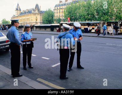 Paris quatre agents de la circulation sur la rue écrivent des tickets de parking. Banque D'Images