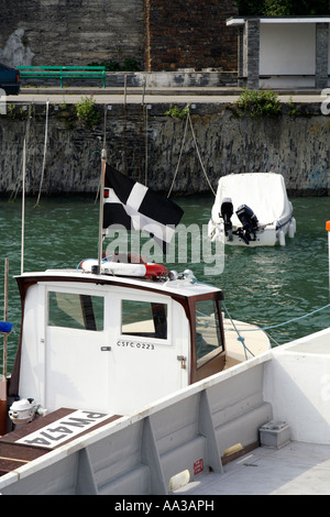 Un drapeau cornouaillais en vol sur un bateau, Padstow, Cornwall, UK. Banque D'Images