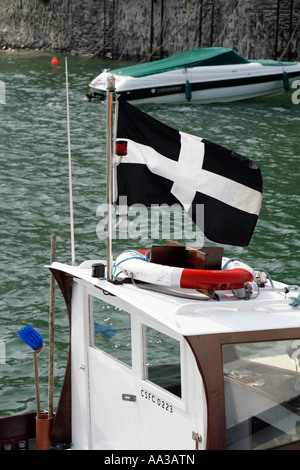 Un drapeau cornouaillais en vol sur un bateau, Padstow, Cornwall, UK. Banque D'Images