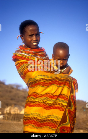 Samburu Jeune femme portant son bébé sur la hanche enveloppé dans du coton coloré au nord du Kenya, Afrique de l'Est Banque D'Images