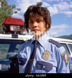Femme grave policier en uniforme debout près de la voiture de police Réserve indienne des Premières nations Lillooet Colombie-Britannique Canada 1990 KATHY DEWITT Banque D'Images