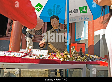 Chine Pékin vendeur vendre Bouddha souriant statues et autres souvenirs religieux dans la cour de la Lama Temple Banque D'Images