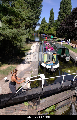 Femme ouvrir une serrure sur le Canal Grand Union UK Banque D'Images