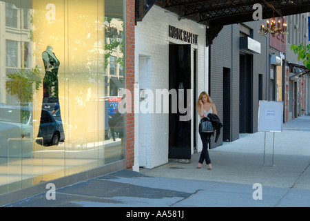 Jeune femme parlant sur un téléphone cellulaire dans le domaine de la maison à la mode West 14 Street, New York City. Banque D'Images
