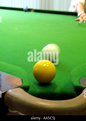 Player hitting la boule blanche vers la balle jaune sur une table de billard Banque D'Images