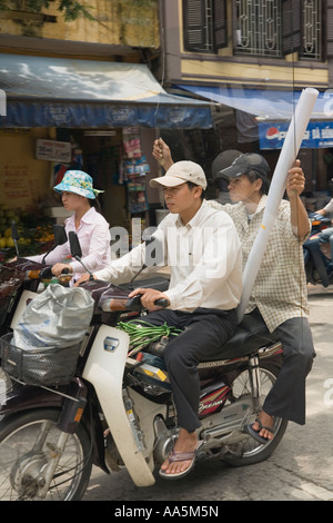 Hanoi, Vietnam. Motocyclistes transportant de larges baies dans le vieux quartier Banque D'Images