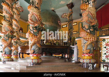 Tay Ninh, Vietnam. Grand Temple de Cao Dai, un prêtre s'occupe de l'Œil divin autel dans le sanctuaire principal Banque D'Images