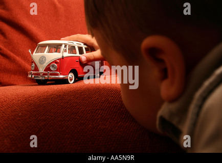 Jeune garçon joue avec vw camper van toy Banque D'Images