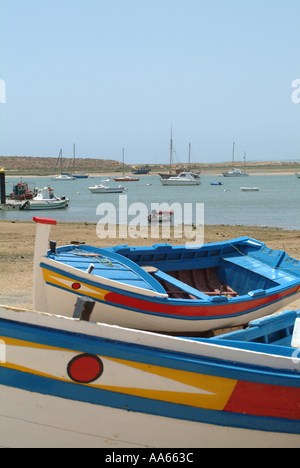 Bateaux de pêche aux couleurs vives à échouée sur la ville d'Alvor Algarve Portugal Banque D'Images