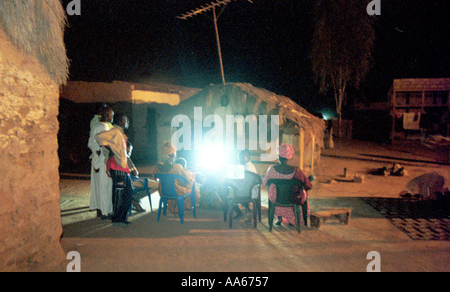 Les réfugiés mauritaniens regarder la télévision en dehors de leurs huttes de boue dans une ville frontière le long du fleuve Sénégal près de Rosso Sénégal La Banque D'Images