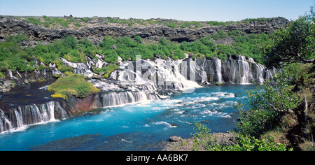 Hraunfossen chute se déversant du dessous de la pierre de lave volcanique en de magnifiques champs de la rivière Hvita bleu appelé dans l'ouest de l'Islande Banque D'Images