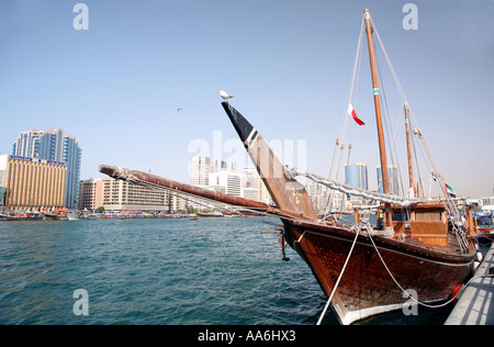 Vue sur la Crique de Dubaï ÉMIRATS ARABES UNIS par un traditionnel boutre en bois au premier plan et les bâtiments modernes du centre de Dubaï derrière Banque D'Images