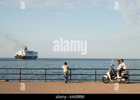 Jeune couple regardant un ferry port en début de soirée, Palerme, Sicile, Italie Banque D'Images