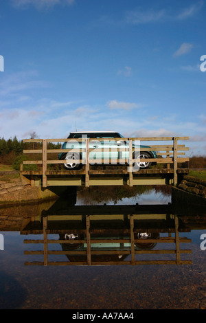 BMW mini sur un pont au-dessus d'un ruisseau dans la nouvelle Forêt Banque D'Images