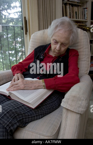 89 ans, femme, et la sieste dans son fauteuil après lecture d'un livre à la maison Banque D'Images