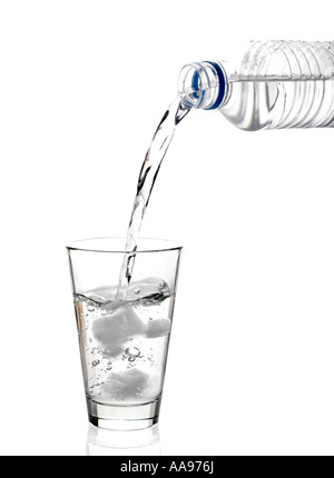 L'eau embouteillée est versé dans un verre Banque D'Images
