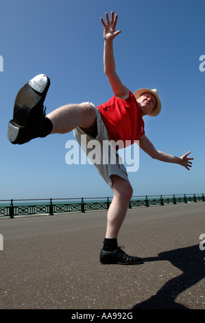 L'une des graves à l'homme d'âge moyen élevé maladroit de faire des coups de danse de routine sur le front de mer de Brighton Banque D'Images