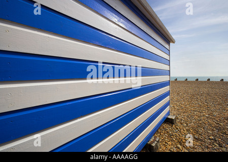 Cabane de plage bleu et blanc avec des bandes horizontales menant à la plage de galets Banque D'Images