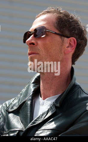 Homme d'une quarantaine d'années portant un leatherjacket et lunettes de vu de profil Banque D'Images