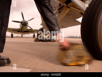 Un pilote SUPPRIME LES CALES D'UN ESPADON AVION À YEOVILTON SOMERSET UK AVEC UN SEA FURY DANS L'ARRIÈRE-PLAN Banque D'Images