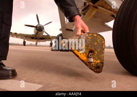 Un pilote SUPPRIME LES CALES D'UN ESPADON AVION À YEOVILTON SOMERSET UK AVEC UN SEA FURY DANS L'ARRIÈRE-PLAN Banque D'Images